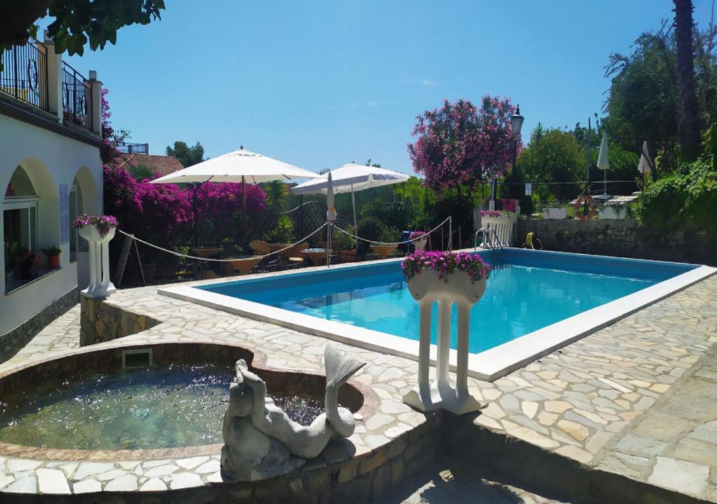 a swimming pool with a fountain in a yard at Hotel Bellavista in San Bartolomeo al Mare