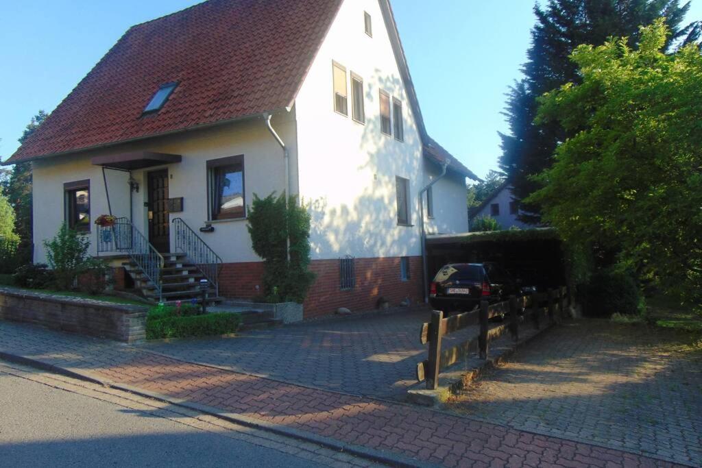 una casa blanca con techo rojo en una calle en Haus Tanja in der Kurstadt Bad Eilsen, en Bad Eilsen