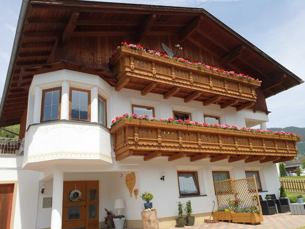 a house with a balcony and flowers on it at Haus Anna Ein Haus mit Herz in Fliess