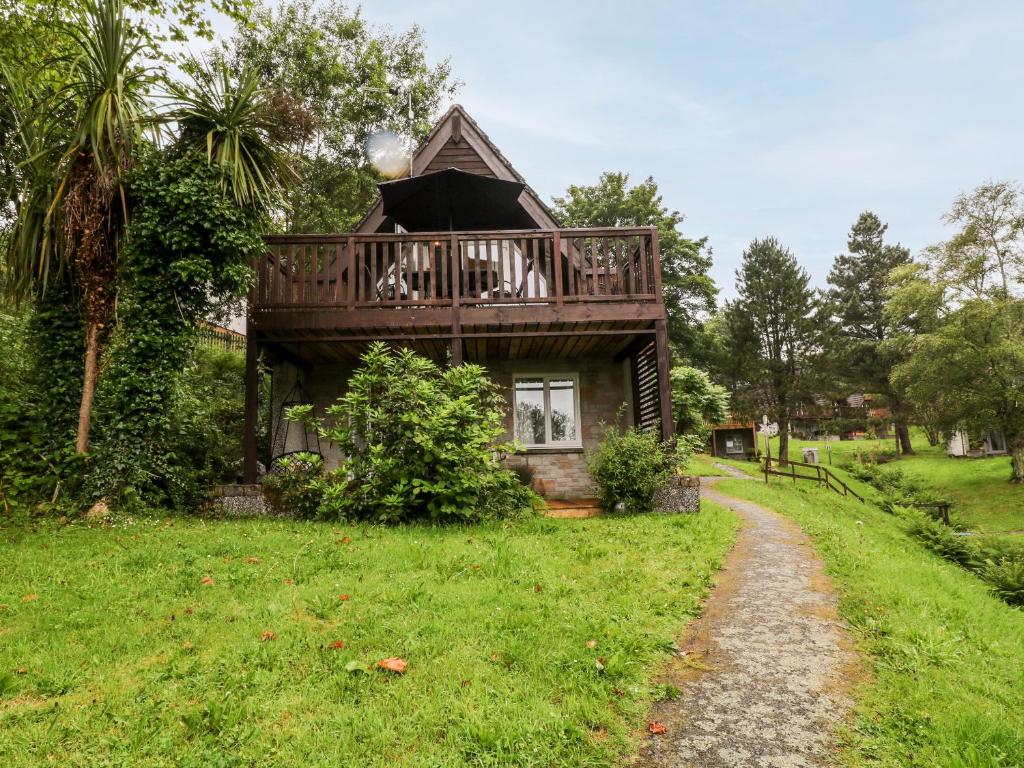 a small house with a deck on a green field at Lavender Lodge in Callington