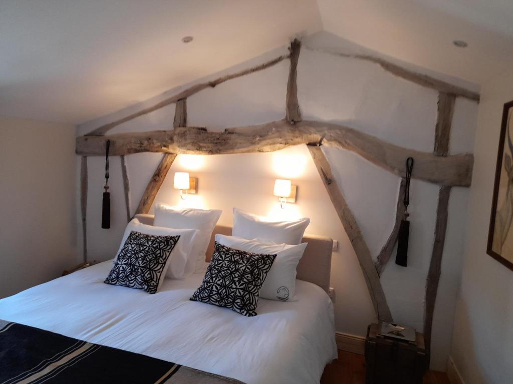 um quarto com 2 camas com lençóis brancos e almofadas em LE CLOS DE L AGNEAU em Saint-Amand-sur-Fion