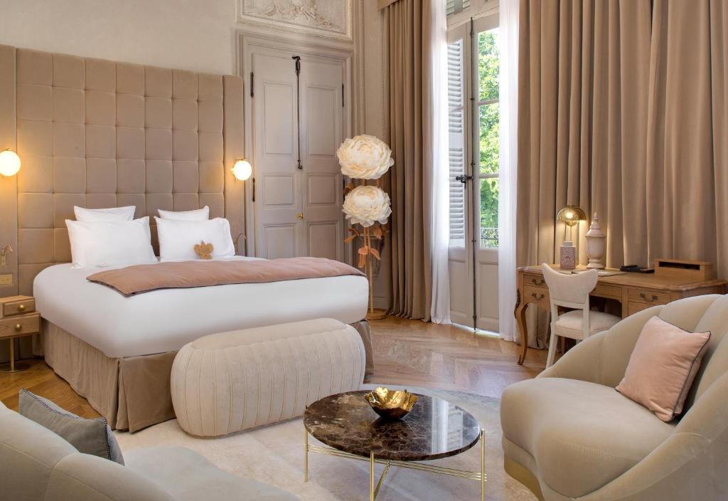 a bedroom with a bed and a living room at Hôtel Richer De Belleval - Relais & Châteaux in Montpellier