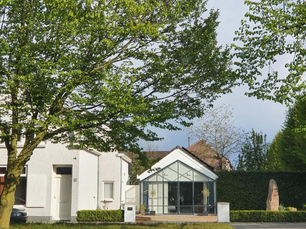 Casa blanca con ventana grande de cristal en Bed and Breakfast en Studio Het Atelier en Goirle