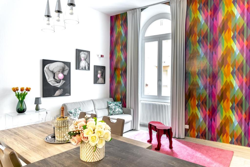 uma sala de estar com uma mesa e uma parede colorida em InLuce Apartment Top Class em Sanremo