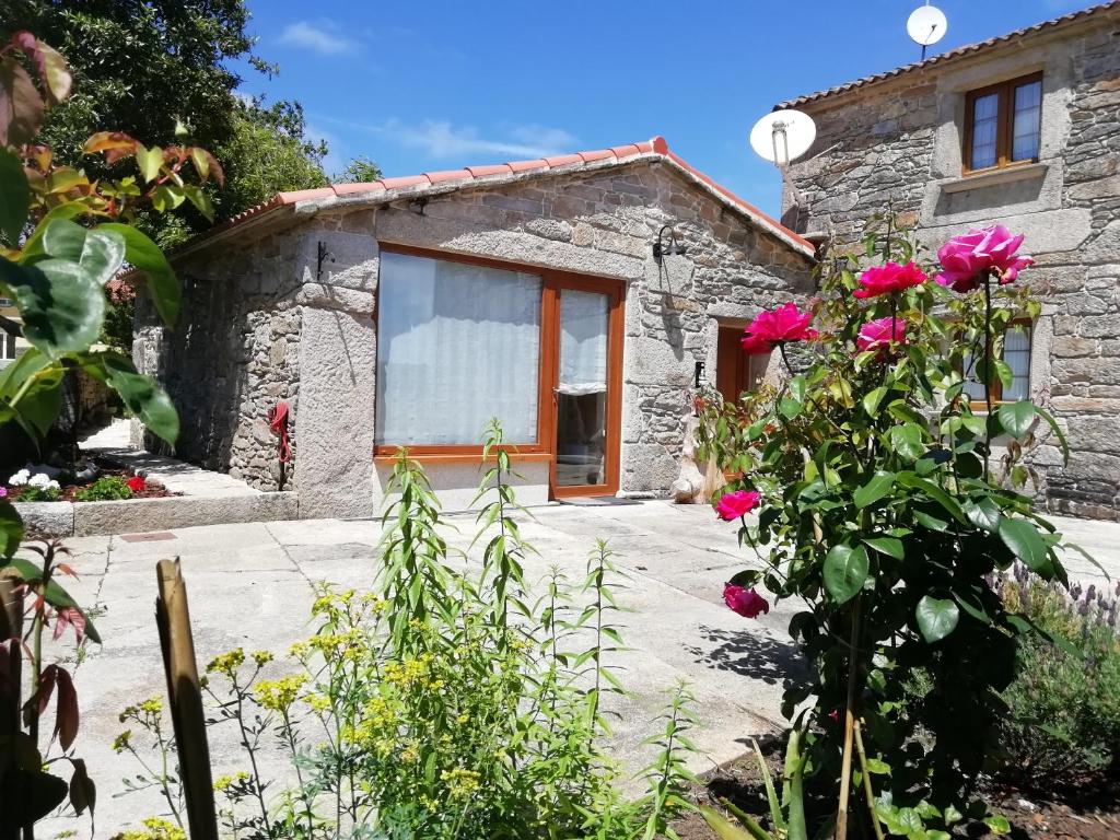 Cabaña de piedra con jardín y flores en Casita vacacional 5 rutas en el rural Costa Da Morte, en A Coruña