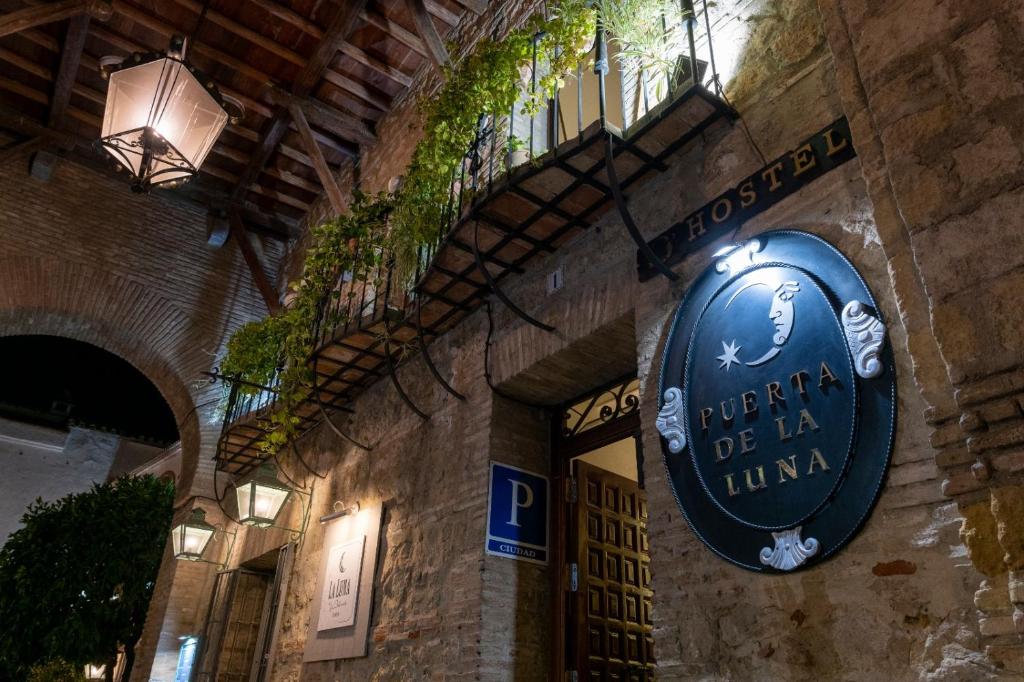 ein Schild für ein Restaurant an der Seite eines Gebäudes in der Unterkunft Puerta de la Luna in Córdoba