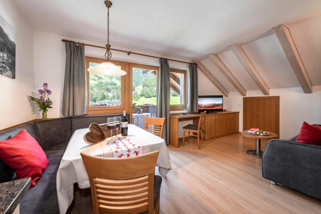 un soggiorno con un tavolo e un divano di Alpenchalet Niederkofler Vera a San Giovanni in Val Aurina