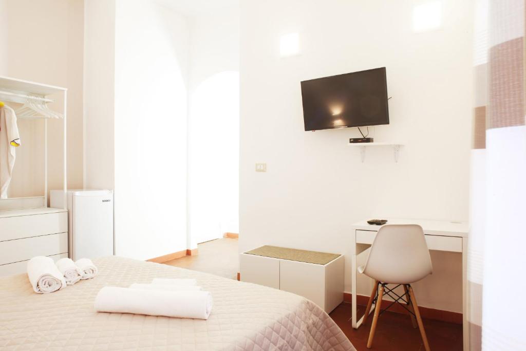 a bedroom with a bed and a desk and a tv at Country Villa San Vito Bay in San Vito lo Capo
