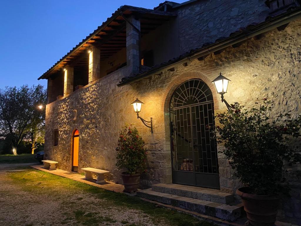 un edificio de piedra con una puerta y luces en él en Agriturismo La Pieve, en Colle Val D'Elsa