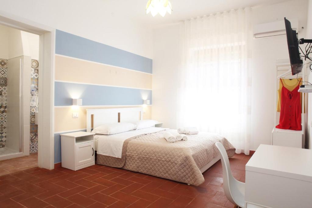 a white bedroom with a bed and a window at Country Villa San Vito Bay in San Vito lo Capo