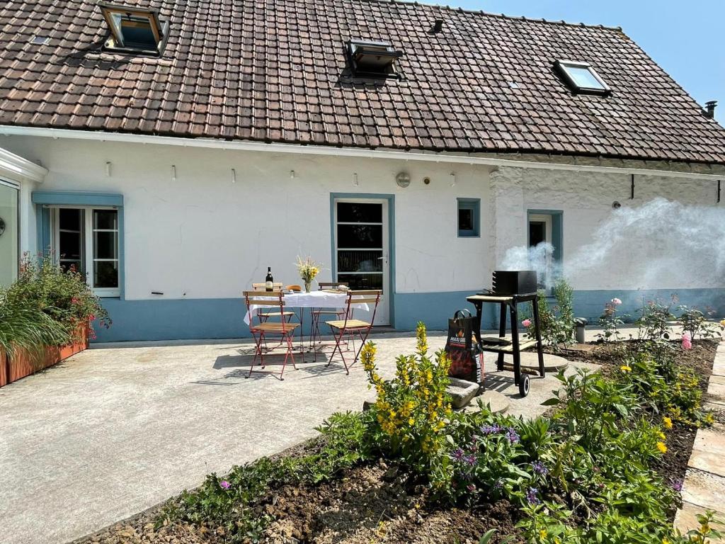 eine Terrasse mit einem Tisch und Stühlen vor einem Haus in der Unterkunft La Tiote Maison in Fiennes