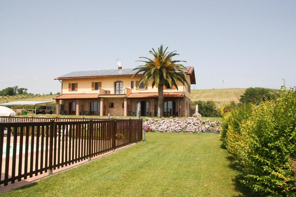 a house with a fence in front of a yard at Casa Vacanza Il Malandrone in Vada