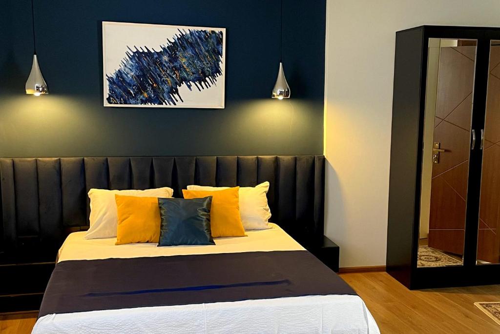 1 cama con almohadas de color naranja y azul en una habitación en Hotel ULYSSES en Mtskheta