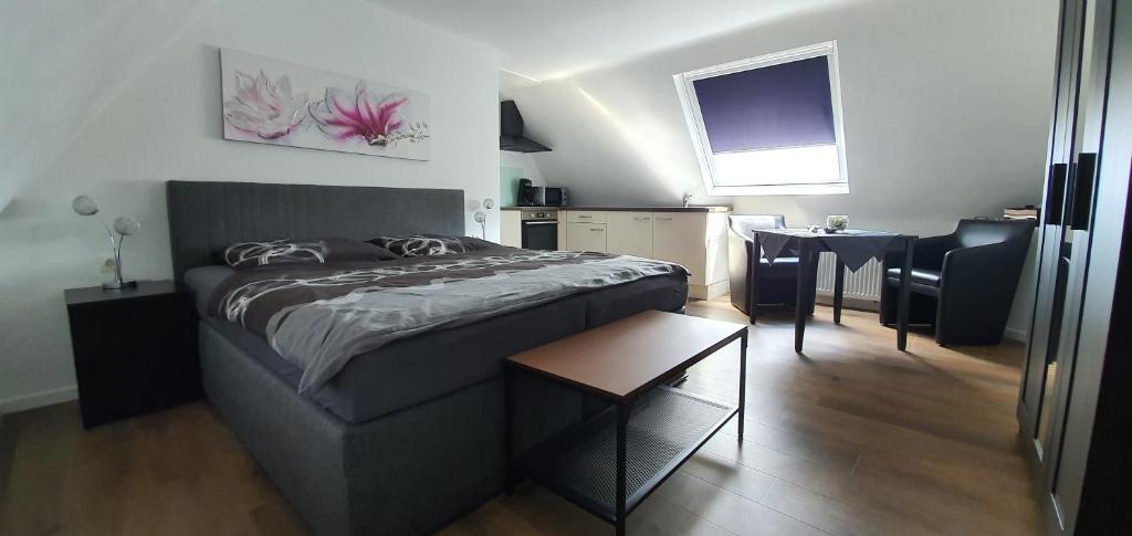 a bedroom with a bed and a table in it at Ferienwohnung Berger Bocholt in Bocholt