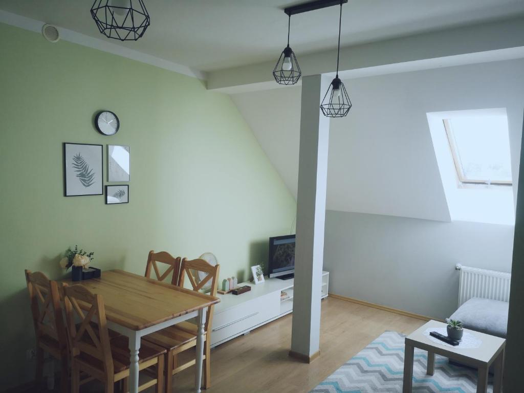 salon ze stołem i krzesłami w obiekcie Apartament Kaktus w mieście Mrągowo
