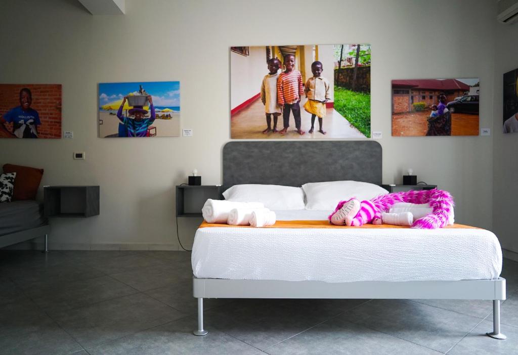 uma cama num quarto com fotografias na parede em Click Art & Room em Trabia