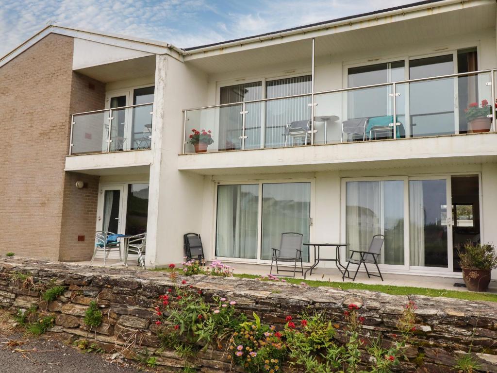 a house with chairs and tables on the balcony at 7 Europa Court in Newquay