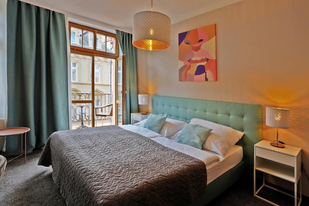 a bedroom with a bed with a blue headboard at Hotel Pilgrim in Karlovy Vary
