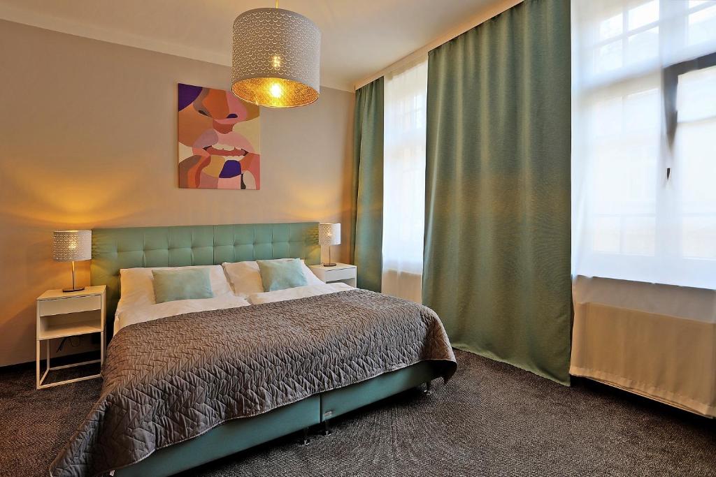 a bedroom with a bed and a large window at Hotel Pilgrim in Karlovy Vary