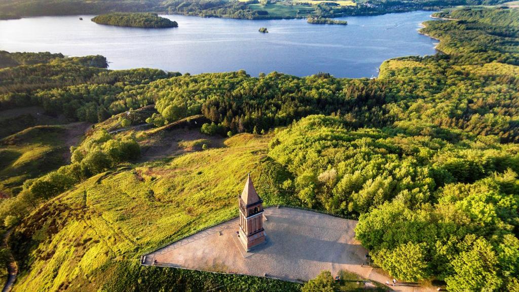 an aerial view of a church on a hill next to a lake at Hotel Ry in Ry