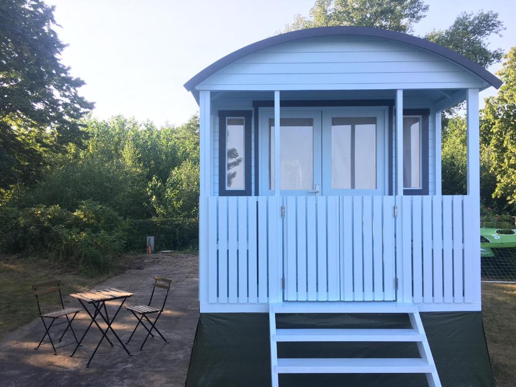 ein blaues Haus mit einem Tisch und Stühlen in der Unterkunft Tiny Beach House in Barkelsby