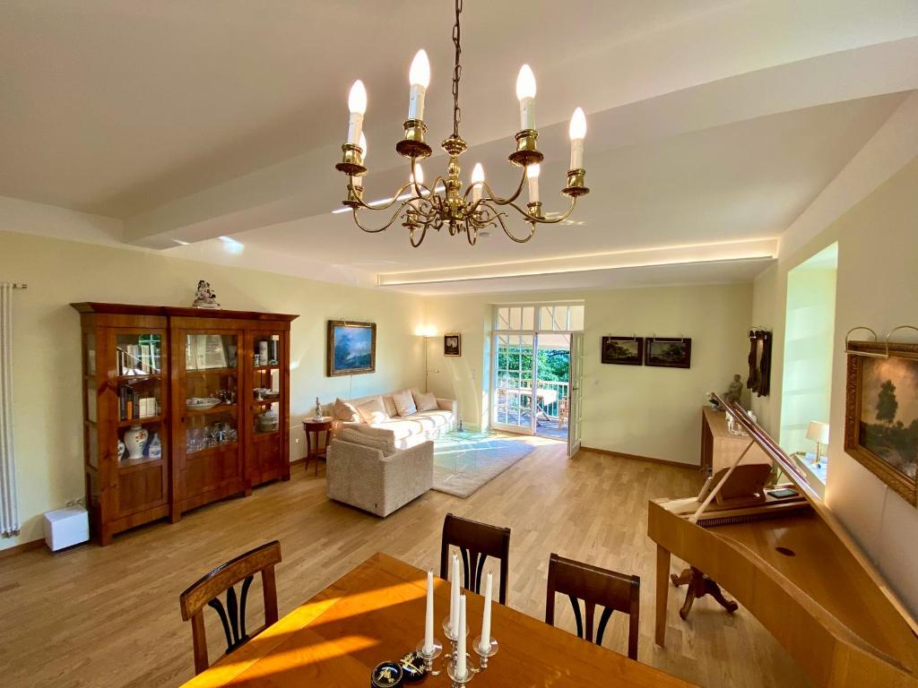 a dining room and living room with a chandelier at Ferienwohnung Natur und Kunst in Dresden