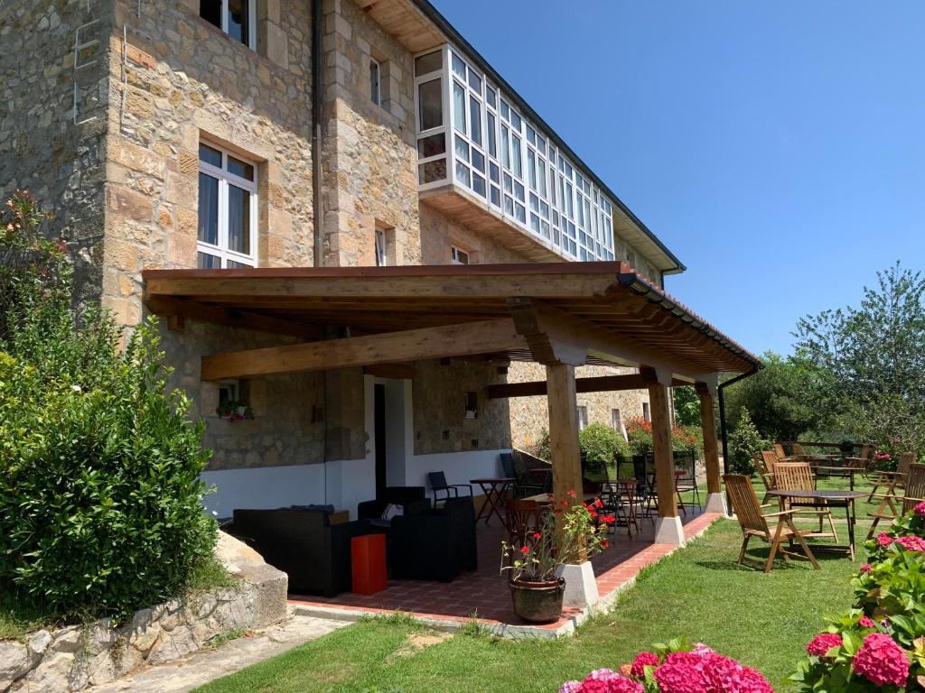 una casa con una pérgola de madera en el patio en Dunas de Oyambre, en Comillas