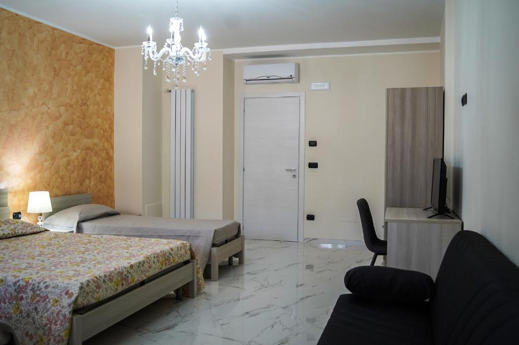 a hotel room with two beds and a chandelier at Demetra Azienda Agricola in Padula
