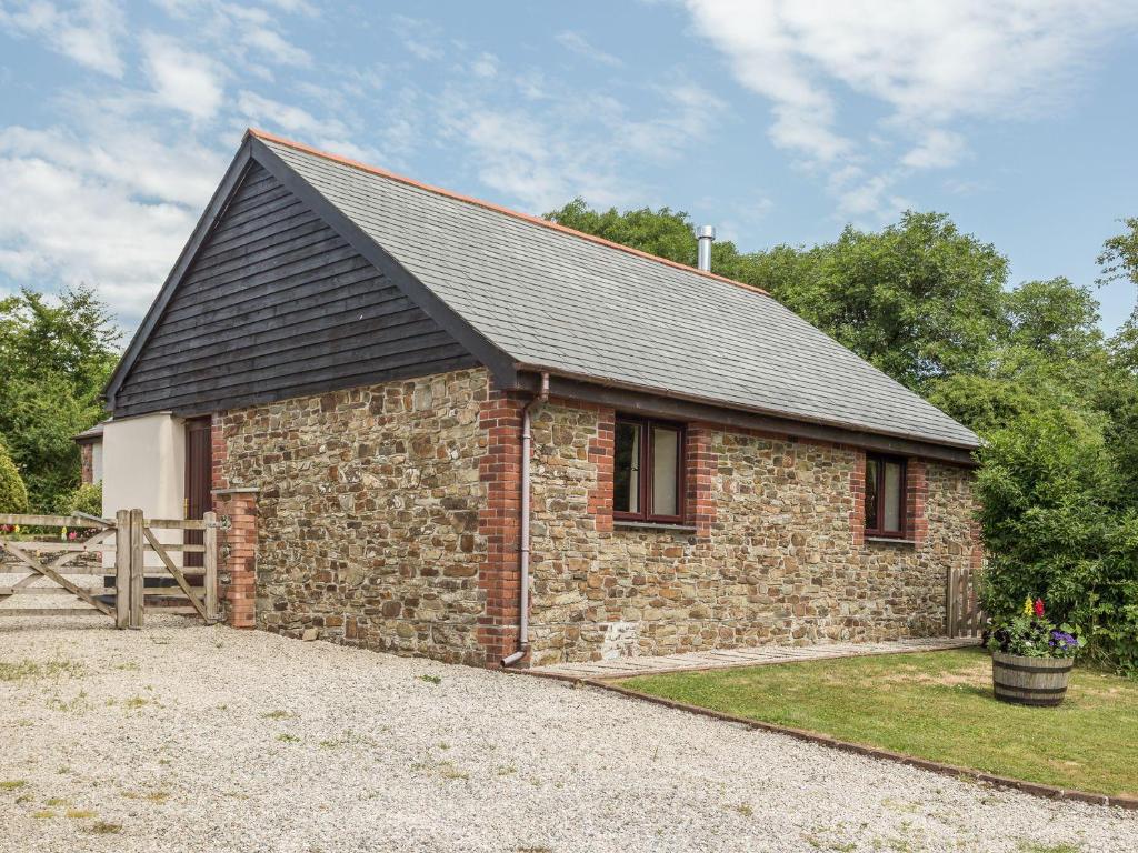 a small brick building with a black roof at Jenny Wren in Holsworthy