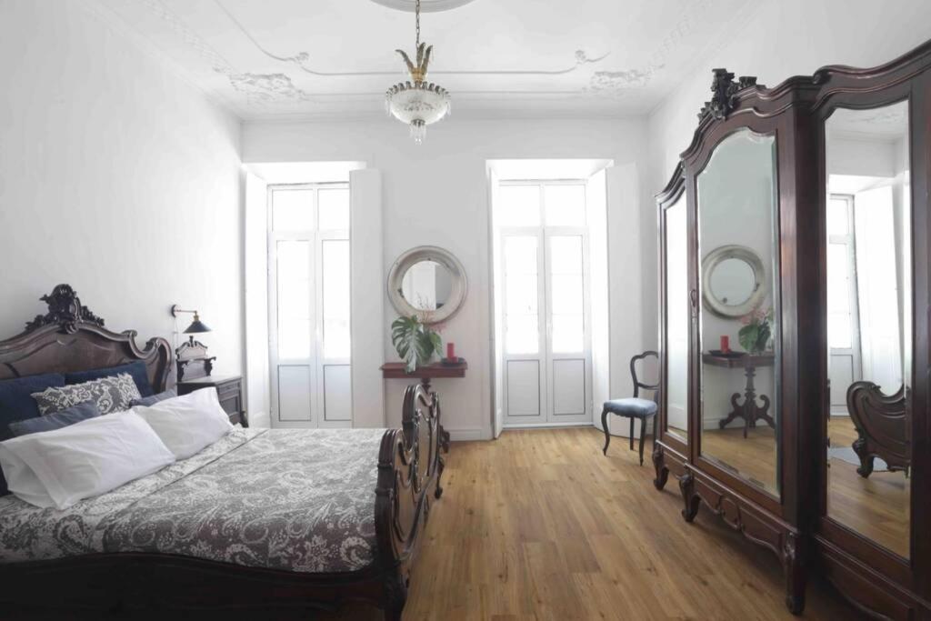 - une chambre avec un lit et un grand miroir dans l'établissement Vila Nova Tower, à Ponta Delgada