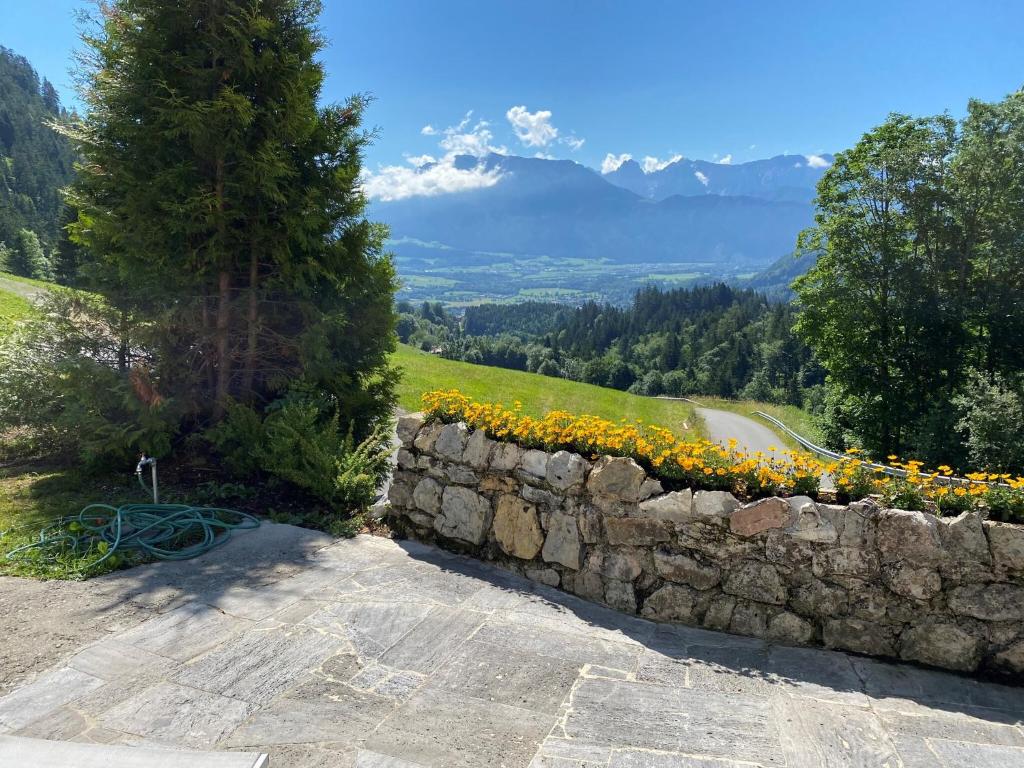a stone wall with sunflowers on top of a mountain at Grabner Riedleiten in Oberaudorf