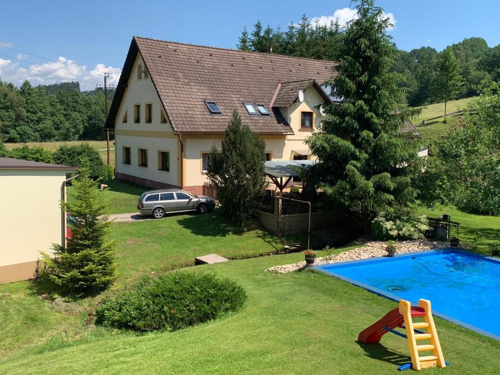 a house with a swimming pool in the yard at Ubytování Chotěvice in Hostinné