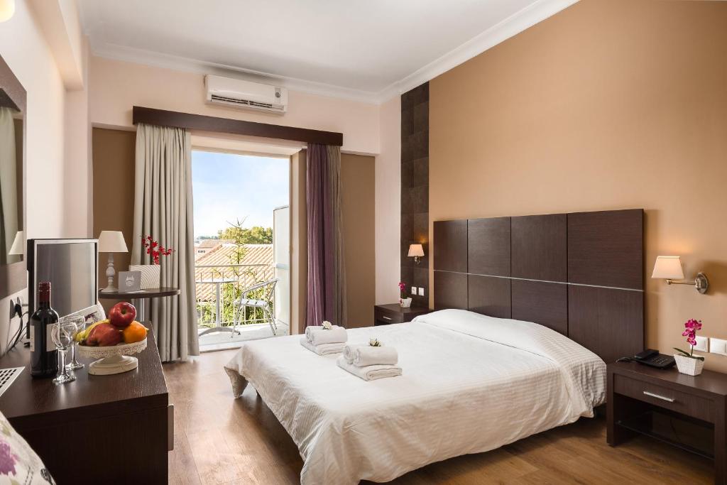 um quarto de hotel com uma cama grande e uma janela em Arion Hotel em Corfu Town