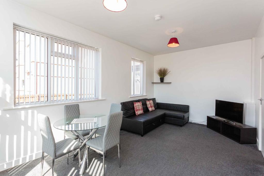 ein Wohnzimmer mit einem Sofa und einem Tisch in der Unterkunft Cherry Property - Mulberry Suite in Blackpool