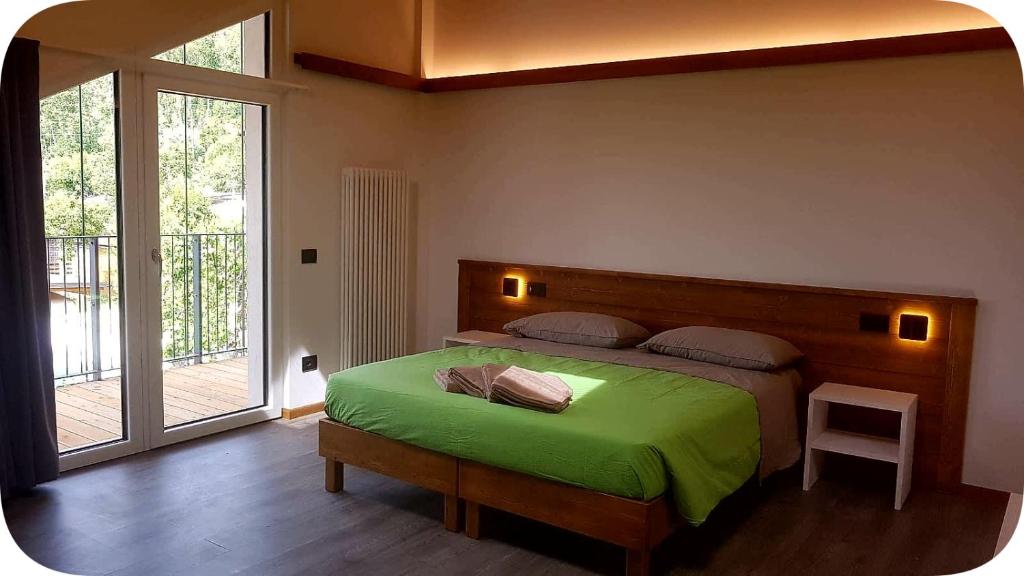 - une chambre avec un lit et une couverture verte dans l'établissement Camping Canè in Fiore, à Baselga di Pinè