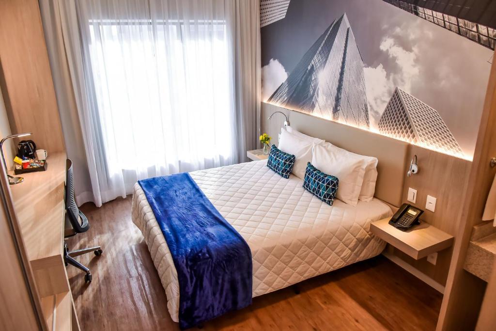 um quarto com uma cama com um cobertor azul em Rio Hotel by Bourbon São Paulo Barra Funda em São Paulo