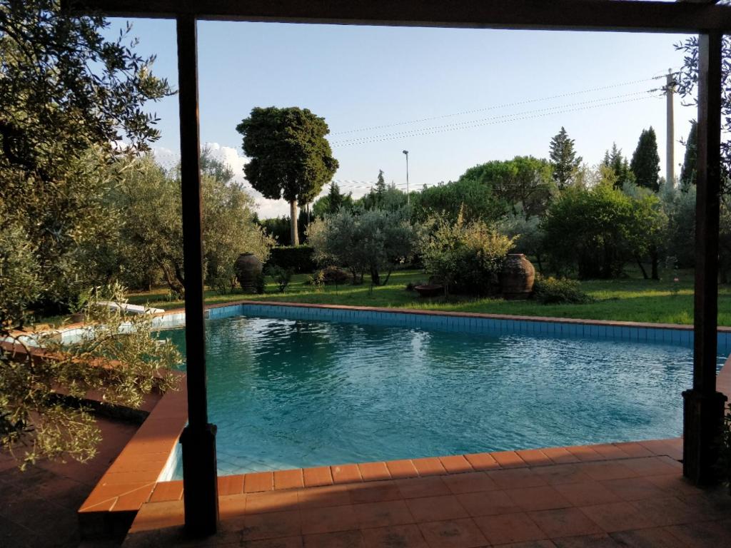 einen Pool in einem Garten mit Bäumen in der Unterkunft Al Canaiolo in Strada