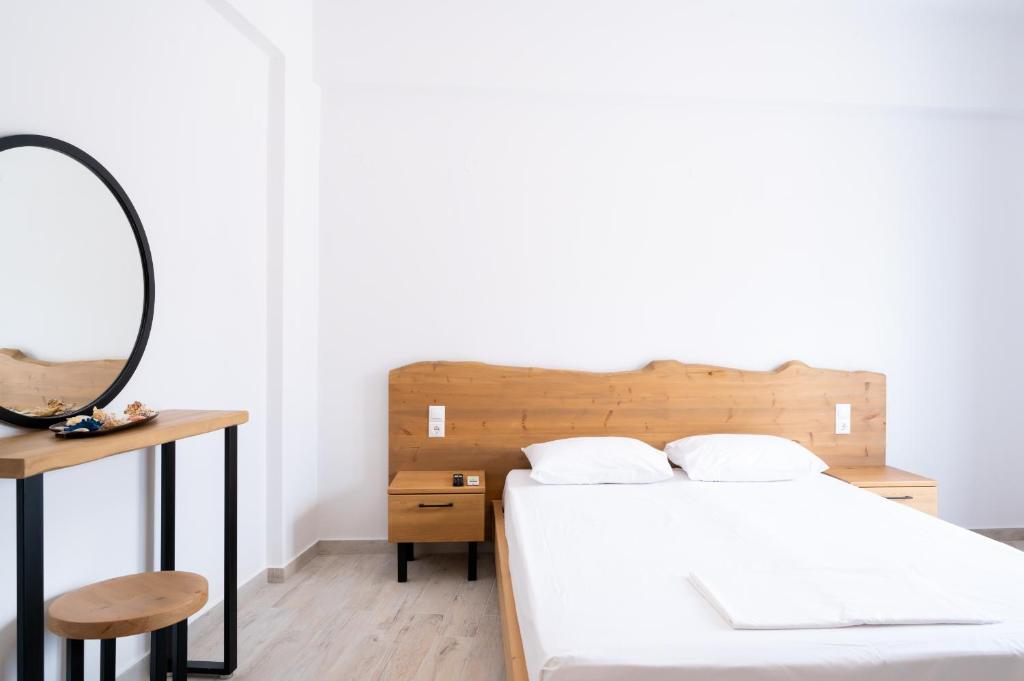 - une chambre avec un lit, un miroir et une table dans l'établissement Valentina's Apartments, à Agia Pelagia