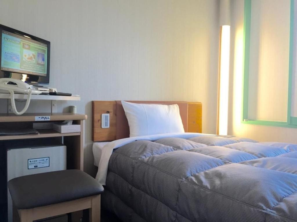 神戸市にあるR&B Hotel Kobe Motomachi - Vacation STAY 40714vのベッドルーム(ベッド1台、テレビ、椅子付)