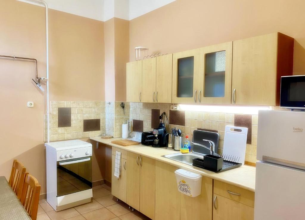 a kitchen with a sink and a refrigerator at Pihi-Lak Apartman Siófok in Siófok