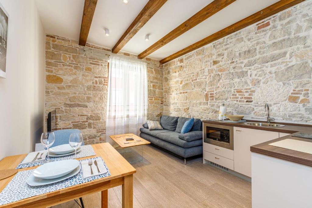 a kitchen and living room with a stone wall at The 3 Figs in Poreč