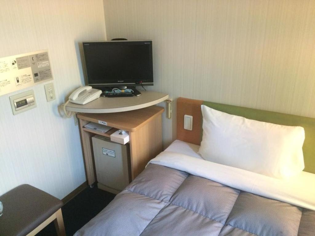 Zimmer mit einem Bett und einem Schreibtisch mit Computermonitor in der Unterkunft R&B Hotel Hakata Ekimae 1 - Vacation STAY 40717v in Fukuoka