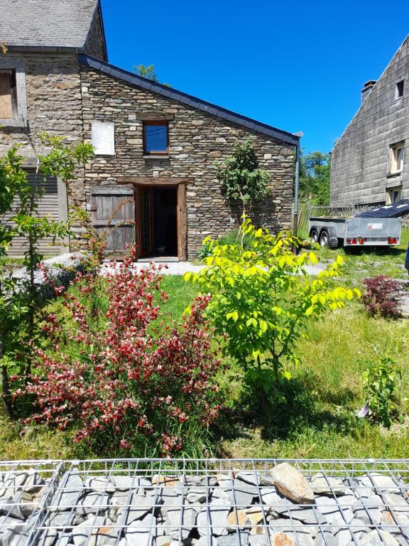 een stenen huis met een tuin ervoor bij Tiny Closerie in Bouillon