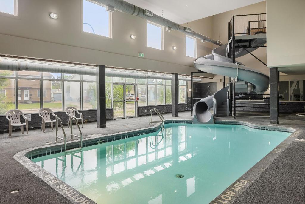 a swimming pool with a slide in a building at Home Inn & Suites Yorkton in Yorkton
