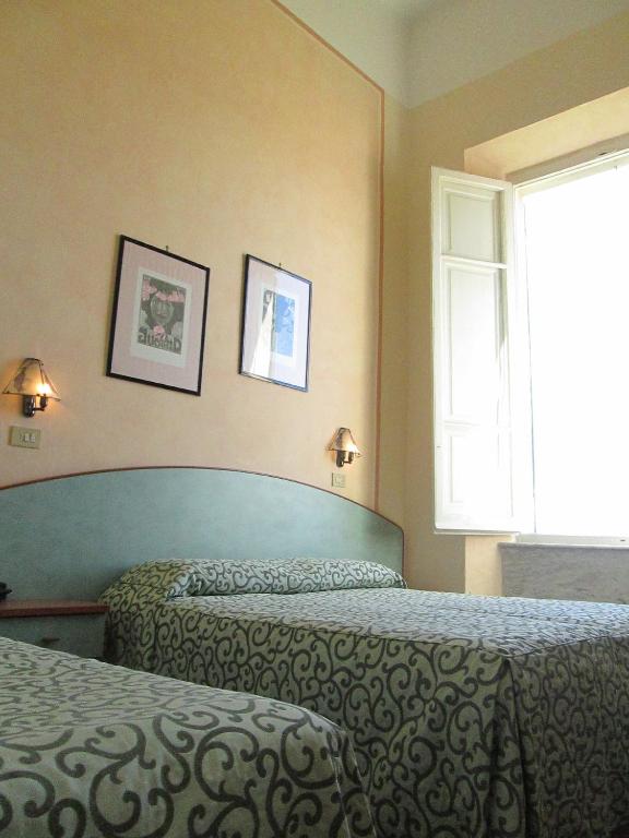 Łóżko lub łóżka w pokoju w obiekcie Hotel Italia