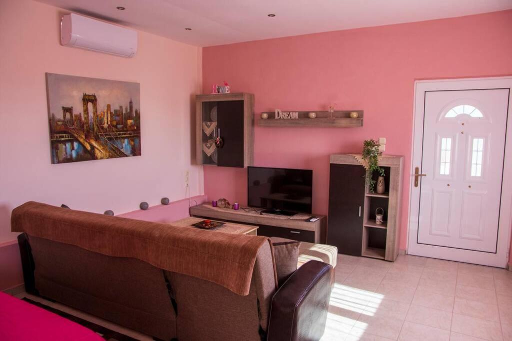 a living room with a couch and a tv at Efi's Home in Zakharo