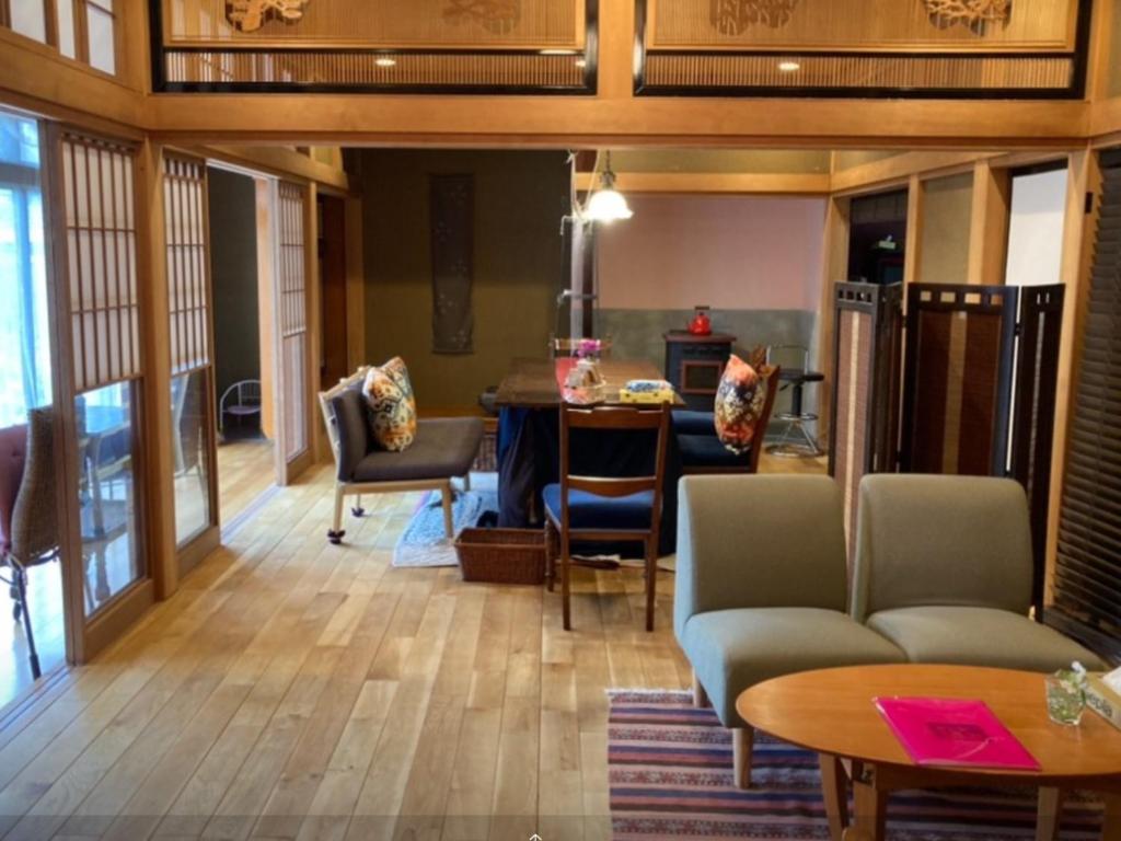 uma sala de estar com um sofá e uma mesa em B&B Ladies Only Grape mama Grape room - Vacation STAY 11649 em Koshu