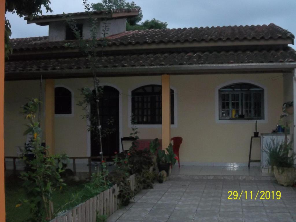 uma pequena casa amarela com um pátio em frente em cantinho do sossego oficial em Caraguatatuba