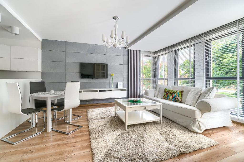 a living room with a white couch and a table at Apartament Eclipse in Szczecin