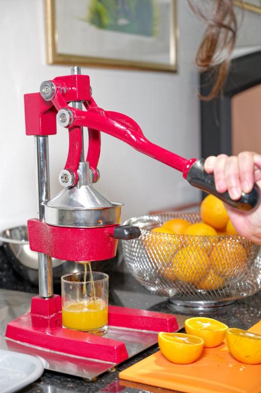 Eine Person schüttet Orangensaft in ein Glas in der Unterkunft Arca Aparthotel &amp; Spa in Zermatt